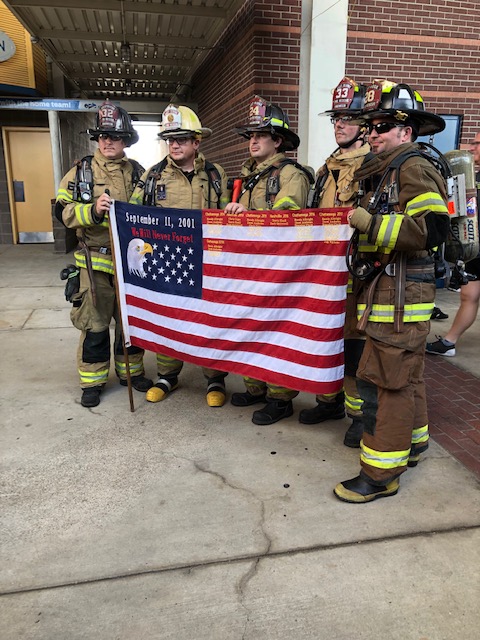firefighters standing with the America flag